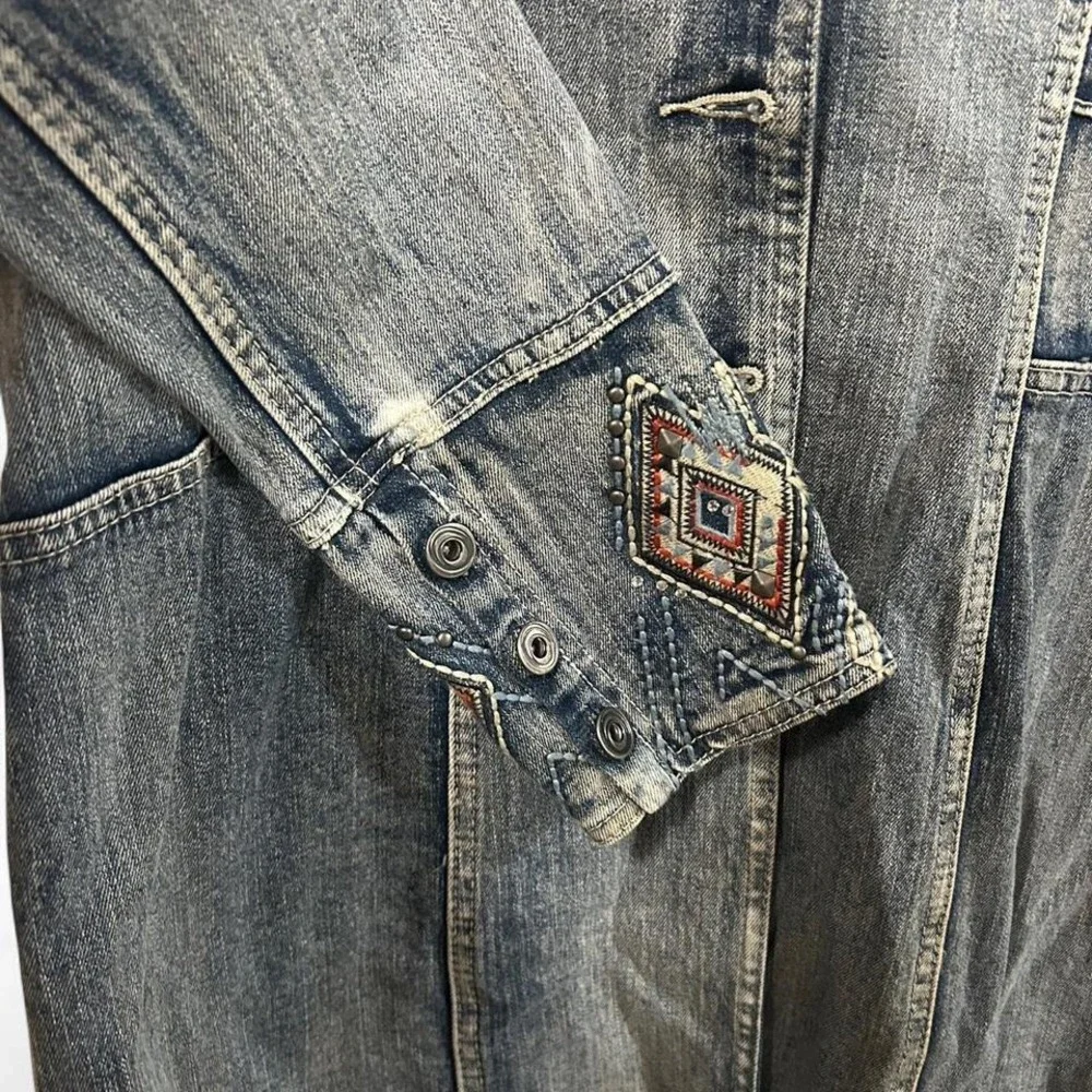 Blue denim jacket with embroidered sleeves,‎ featuring a boho western vibe
